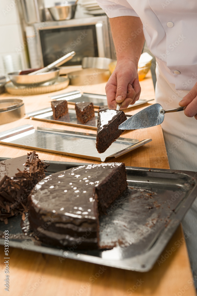 Confectioner cutting a slice of chocolate cake Confectioner cutting a slice of chocolate cake