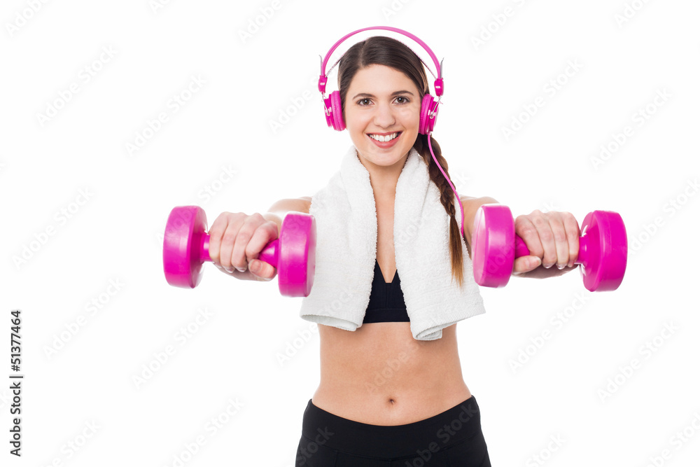 Woman enjoying music while doing dumbbells Woman enjoying music while doing dumbbells