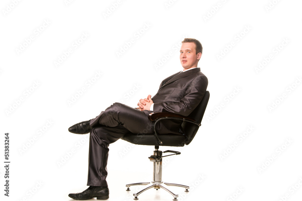 Confident smiling young businessman sitting on a chair Confident smiling young businessman sitting on a chair