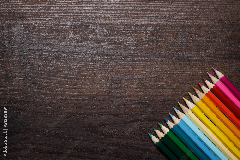 colorful pencils over brown table background colorful pencils over brown table background