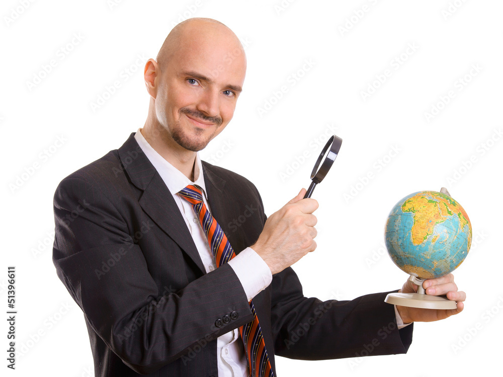 Mann schaut mit Lupe auf Globus Stock-Foto | Adobe Stock
