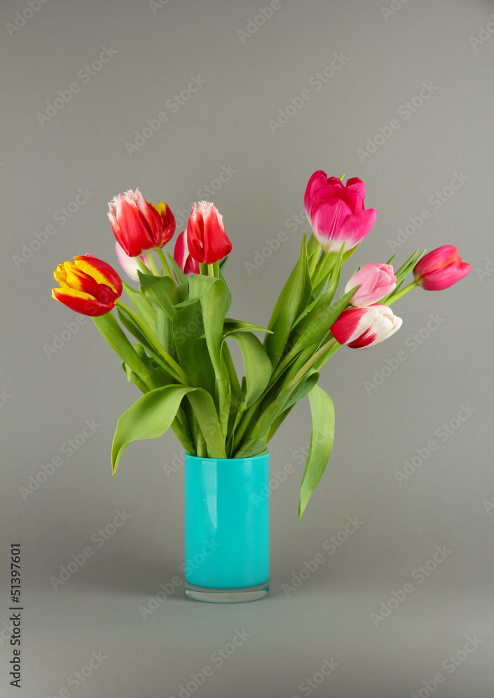 Beautiful tulips in bucket on grey background Beautiful tulips in bucket on grey background