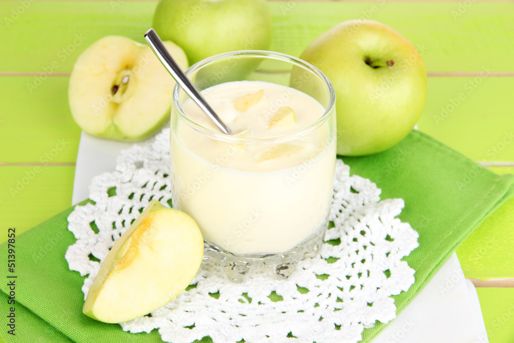 Delicious yogurt in glass with apple on blue tablecloth Delicious yogurt in glass with apple on blue tablecloth