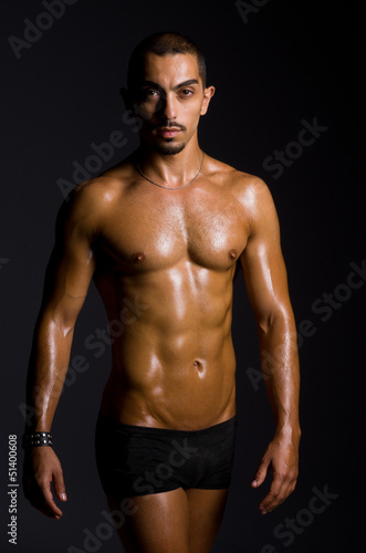 Muscular man in dark studio