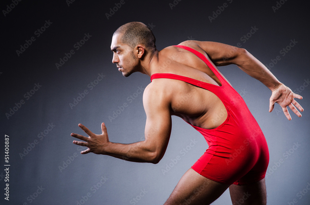 Young wrestler in dark studio Young wrestler in dark studio