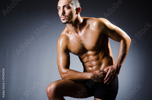 Muscular man in dark studio