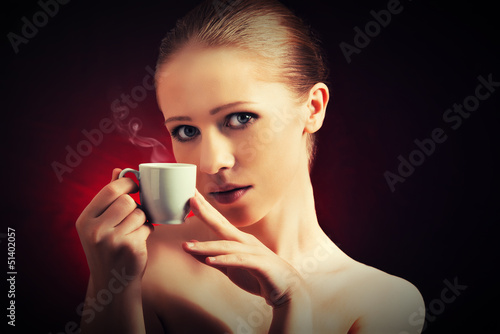 sexy woman enjoying a hot cup of coffee on a dark background