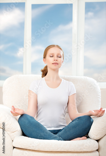 woman meditating, relaxing, sitting in a lotus position on the
