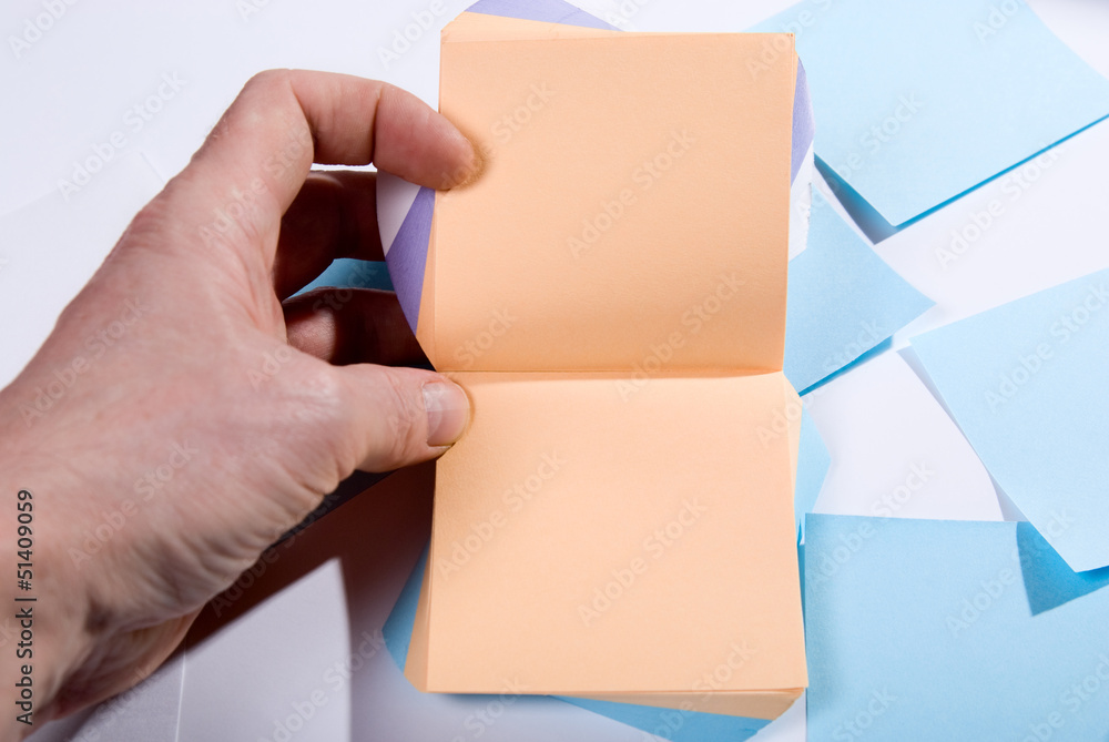 Fototapeta premium Block of post-it notes. Hand holding blank pages for notes