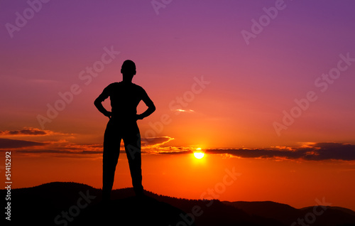 Silhouette of young man in the mountains at sunset