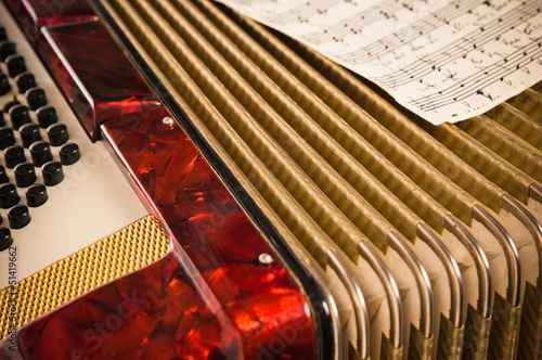Red accordion and sheet music, closeup