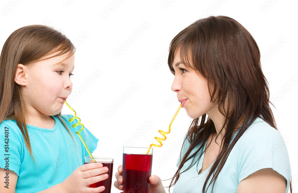 Mother and her daughter are drinking juice Mother and her daughter are drinking juice