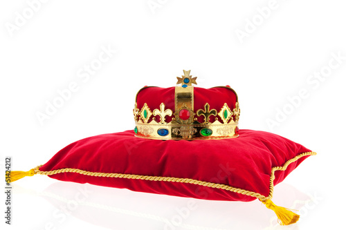 Golden crown on velvet pillow