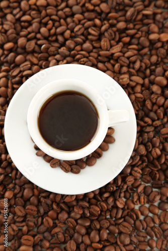 Cup of coffee on coffee beans background