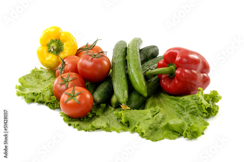 Green cucumber with red tomato and paprika on green lettuce