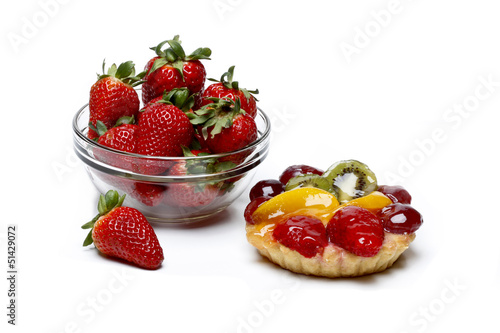 Fresh strawberries versus unhealthy cake isolated on white