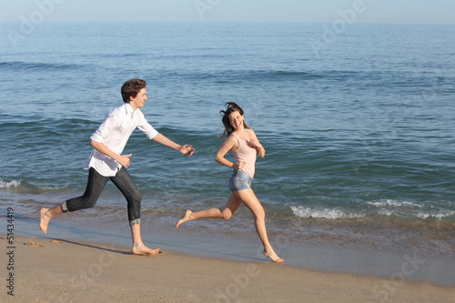Couple playing and running on the beach