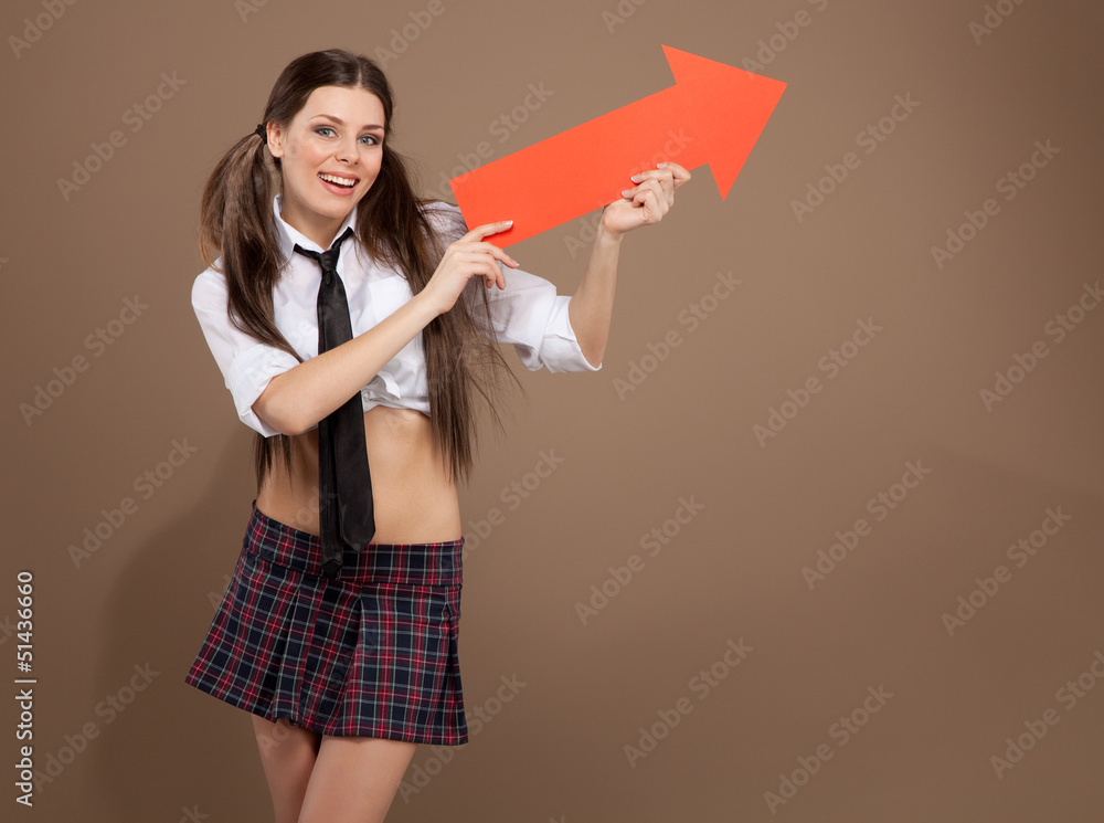 Woman in a schoolgirl costume holding an arrow sign