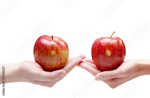 Two hands give each other an apple