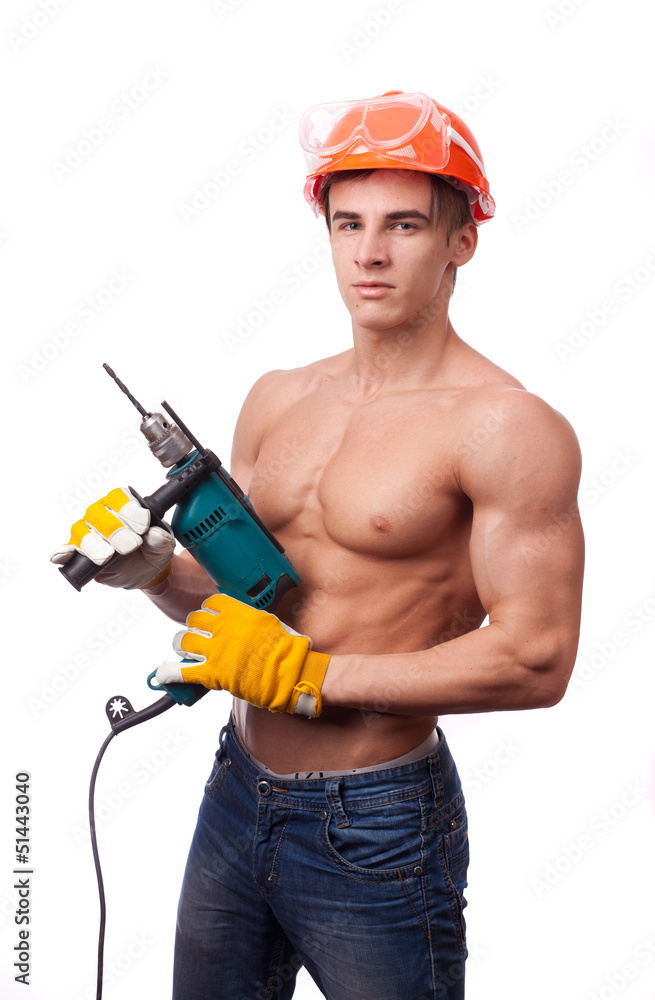 Muscular worke with an electric drill on a white background. Muscular worke with an electric drill on a white background.