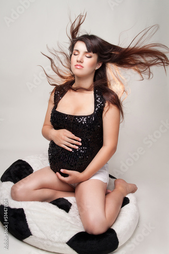 The pregnant woman sitting on a padded stool in the form of a ba