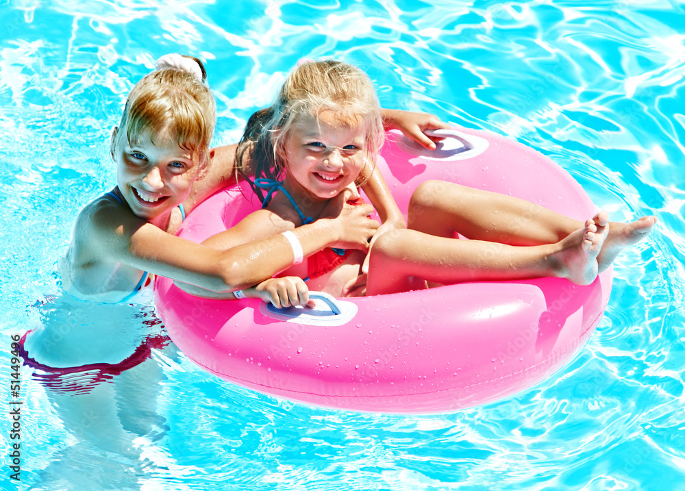 Children sitting on inflatable ring.
