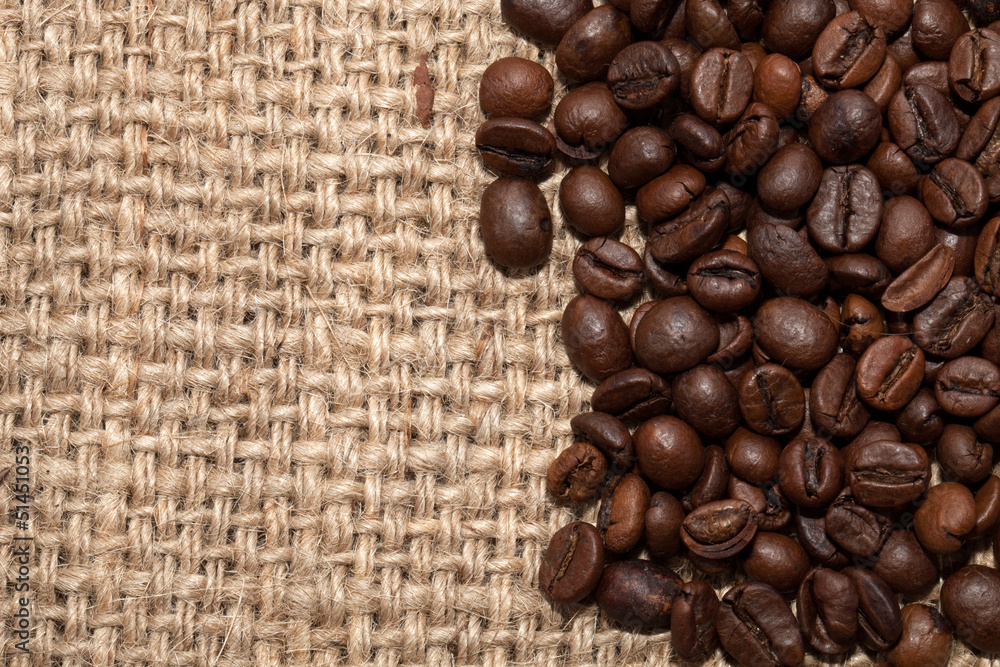 Coffee grains on rough fabric of linen close-up Coffee grains on rough fabric of linen close-up