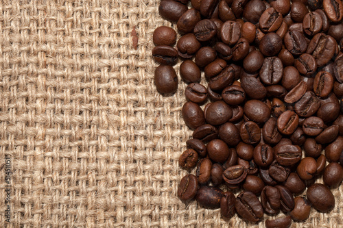Coffee grains on rough fabric of linen close-up