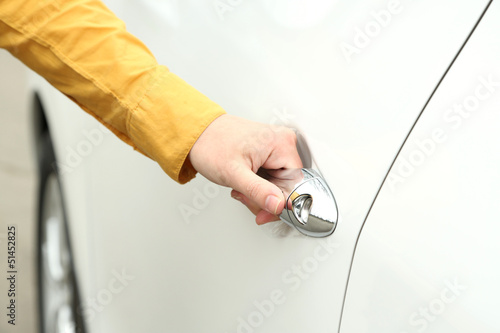 Woman hand opening car door, close up