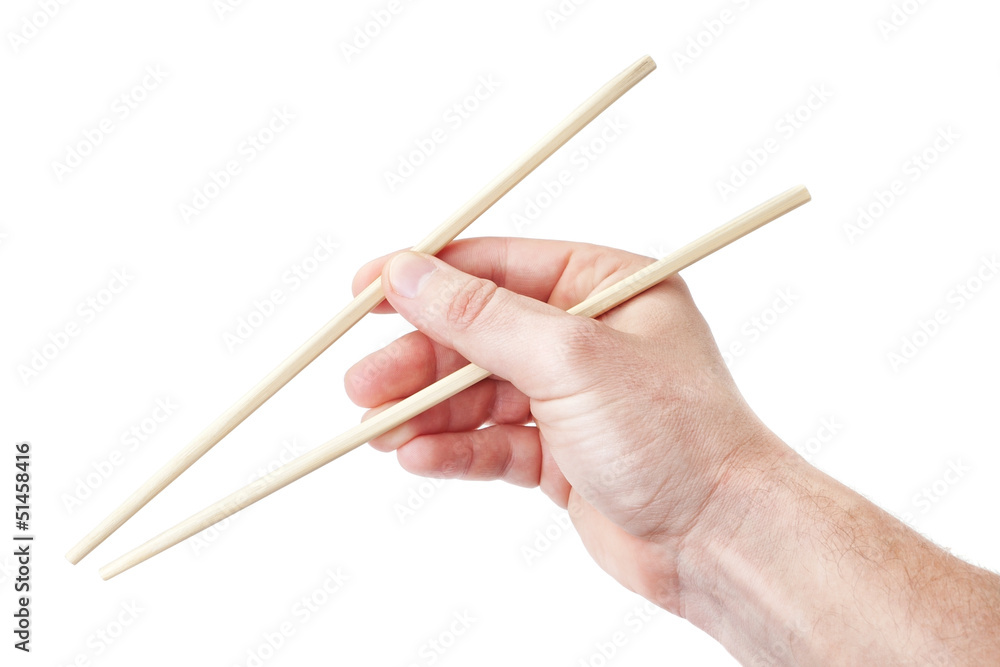Chinese sticks chopsticks, in a man's hand for sushi. On a white Chinese sticks chopsticks, in a man's hand for sushi. On a white