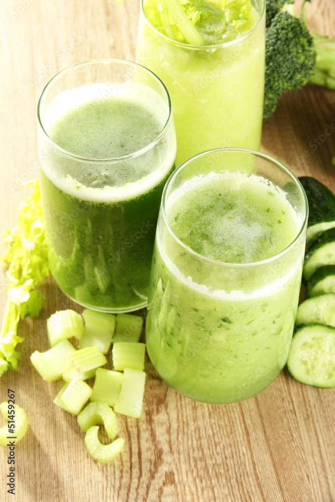 Glasses of green vegetable juice on wooden background Glasses of green vegetable juice on wooden background