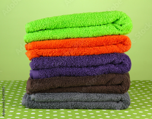 Pile of colorful towels, on green background
