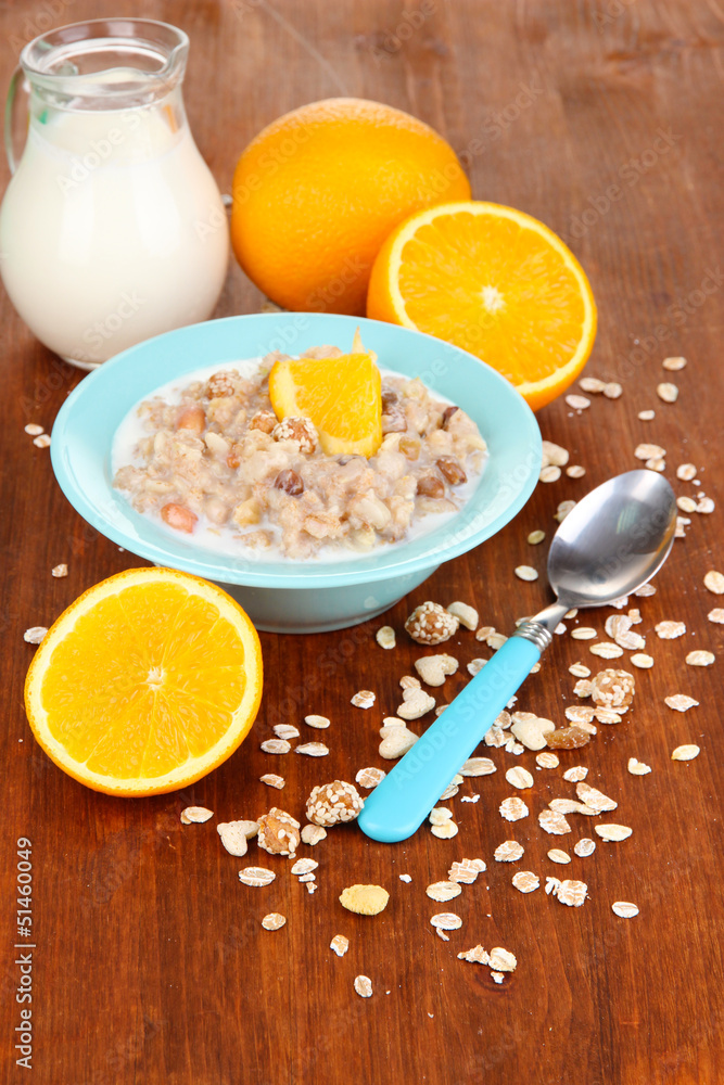 Useful oatmeal in bowl with fruit on wooden table close-up Useful oatmeal in bowl with fruit on wooden table close-up