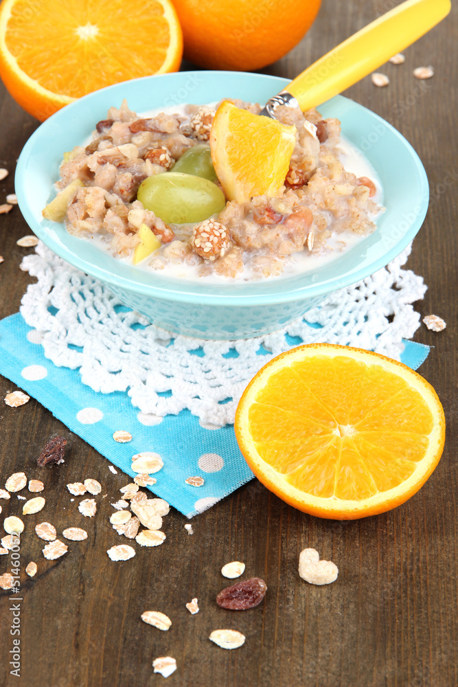 Useful oatmeal in bowl with fruit on wooden table close-up Useful oatmeal in bowl with fruit on wooden table close-up