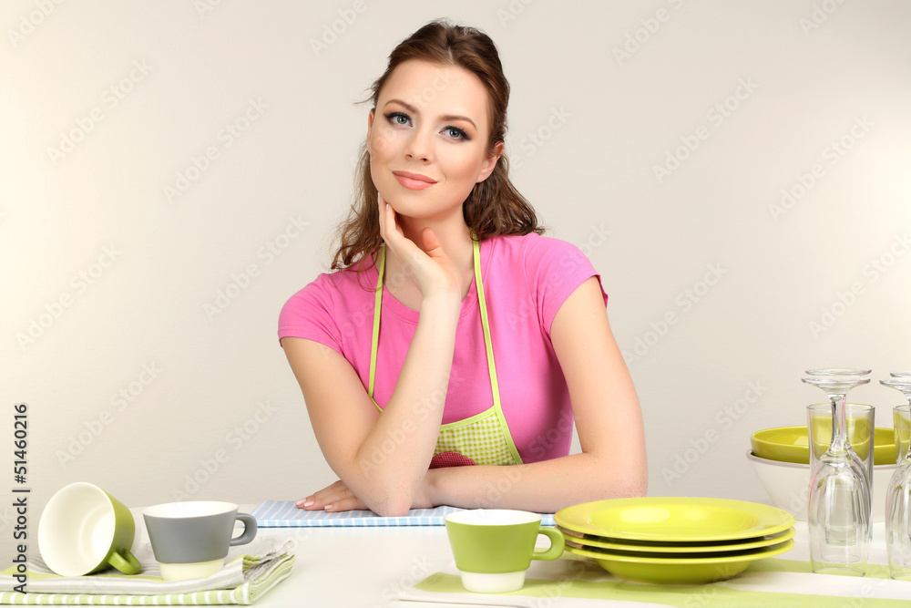 Beautiful young woman wipes clean utensils in kitchen Beautiful young woman wipes clean utensils in kitchen