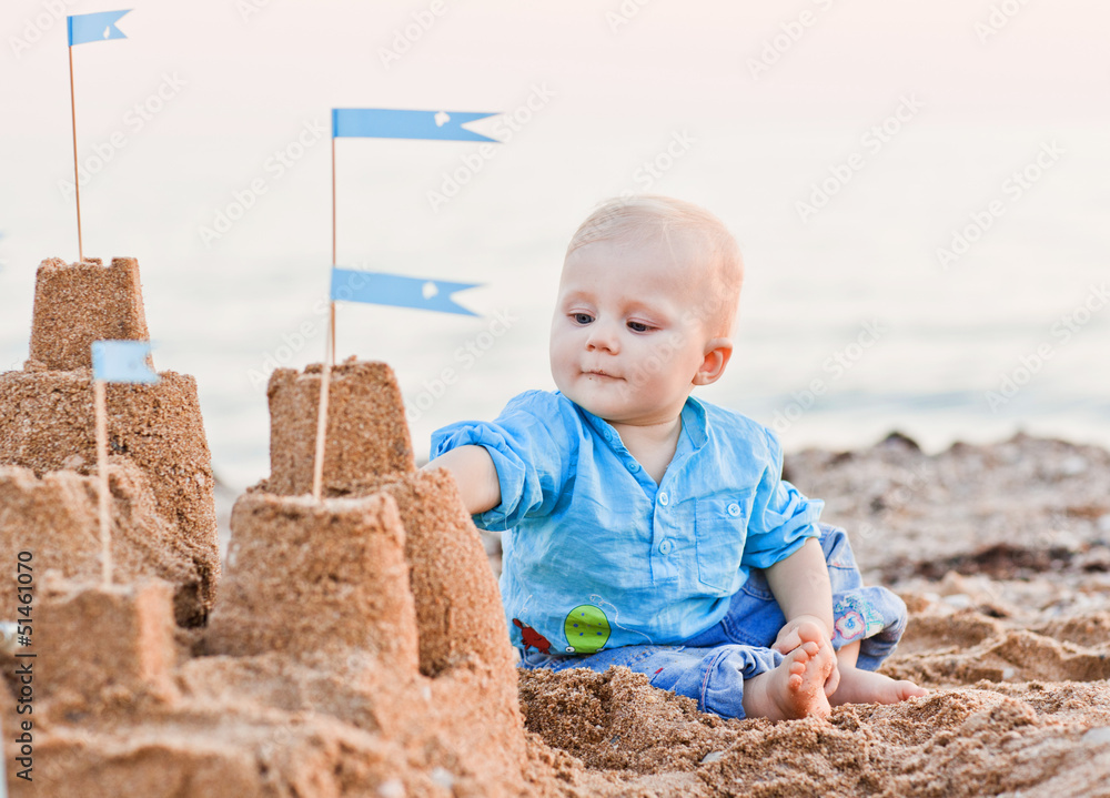 cute boy playing with sand on beach