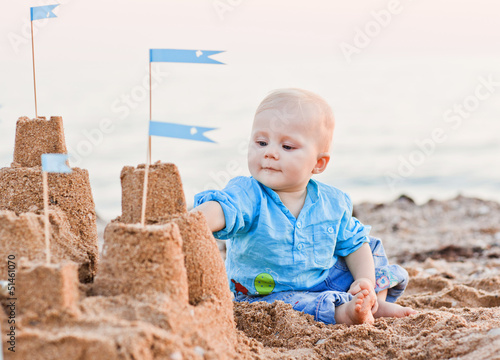 Obraz na płótnie cute boy playing with sand on beach w salonie