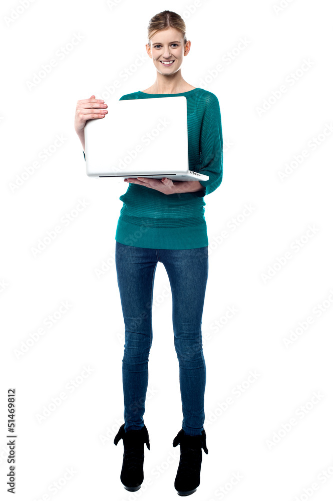 Full length shot of smiling girl holding laptop