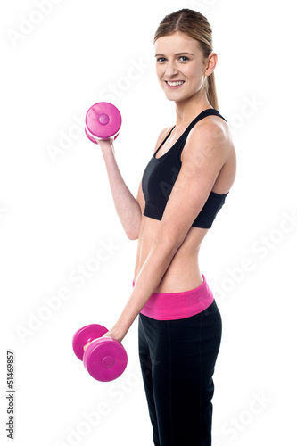Fitness female instructor lifting dumbbells