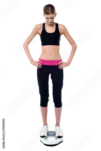 Slim fit tall girl measuring her weight © stockyimages