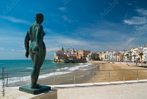 Statue of a naked woman against Sitges town view
