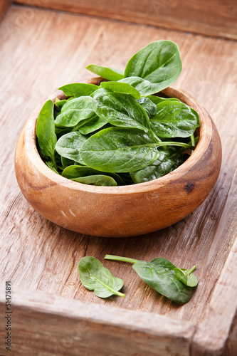Young spinach in wooden bowl