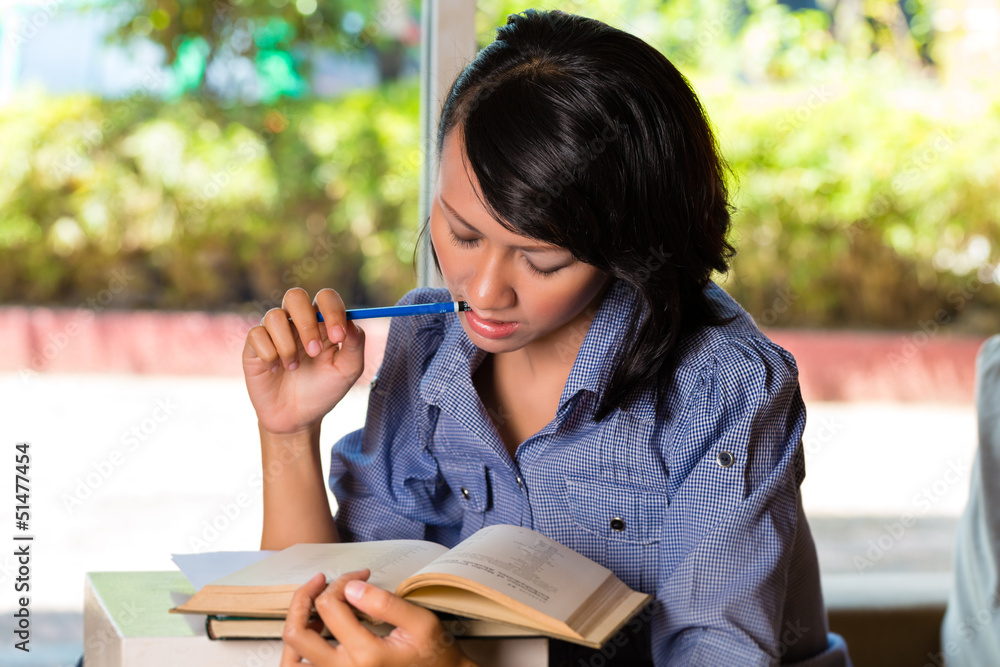 Fototapeta premium Girl with pile of books learning
