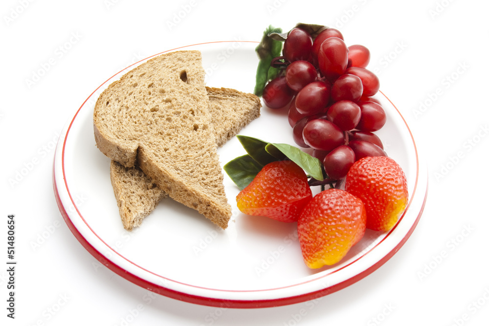 Plastik Trauben und Erdbeeren mit Vollkornbrot auf Teller Plastik Trauben und Erdbeeren mit Vollkornbrot auf Teller