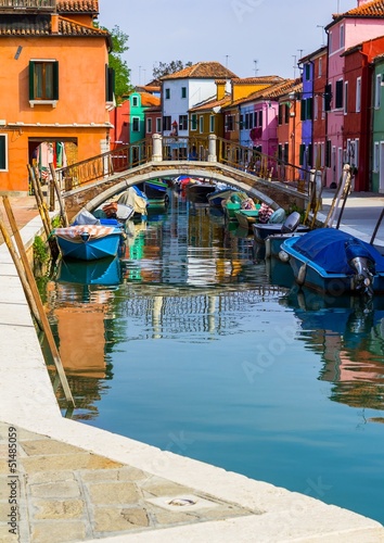Channel in Burano island full of boats and colorful houses © eldeiv