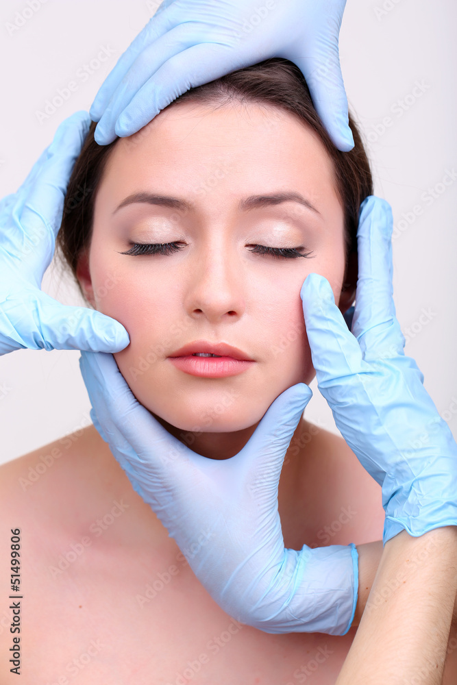 Rubber gloves touching face of young woman close up Rubber gloves touching face of young woman close up