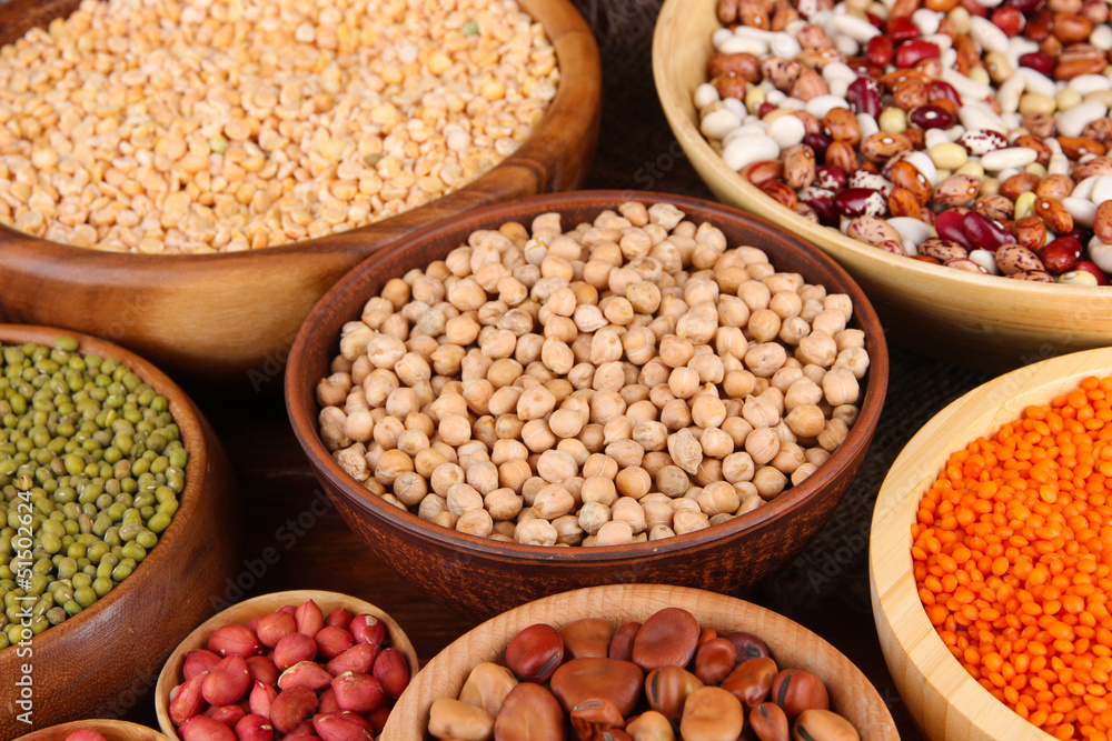 Different kinds of beans in bowls on wooden background Different kinds of beans in bowls on wooden background