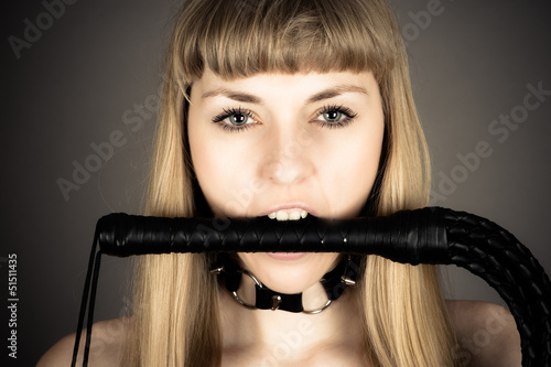 submissive woman holding a whip in his mouth
