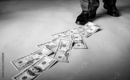 Men's feet and dollar banknotes on the floor