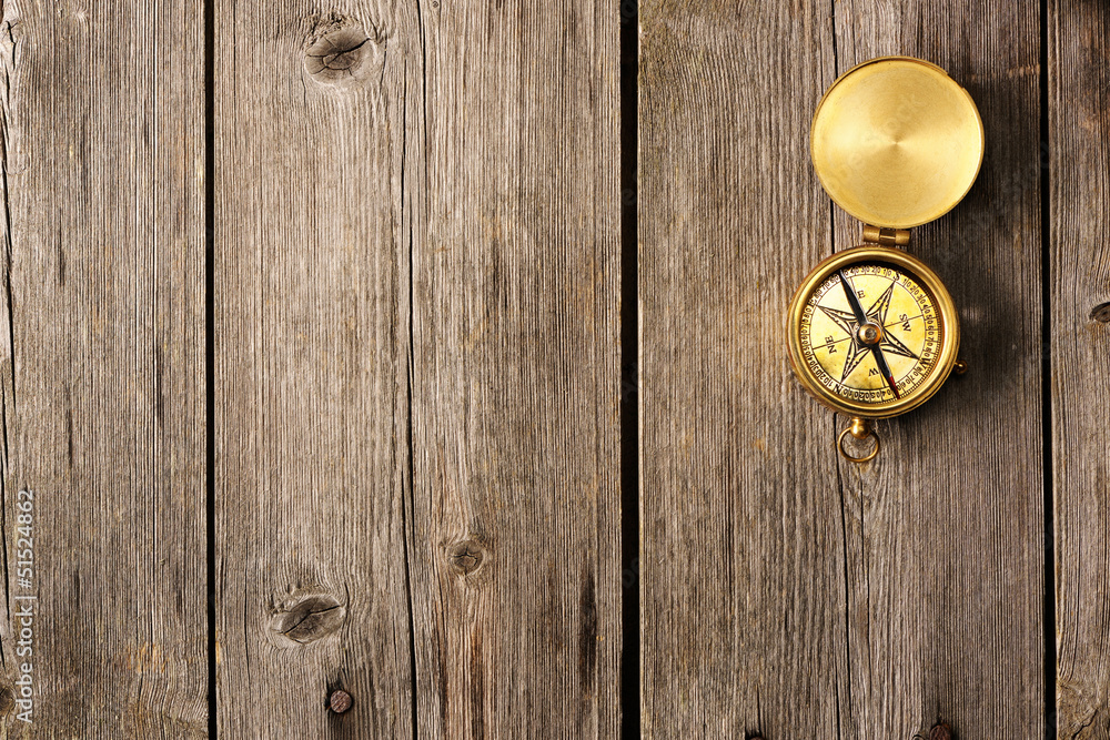 Fototapeta premium Antique compass over wooden background